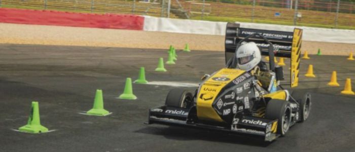 A student driving a Formula 1 car