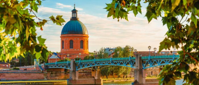 Toulouse, France. Beautiful cityscape with The River Garonne and La Grave dome in the background at sunset