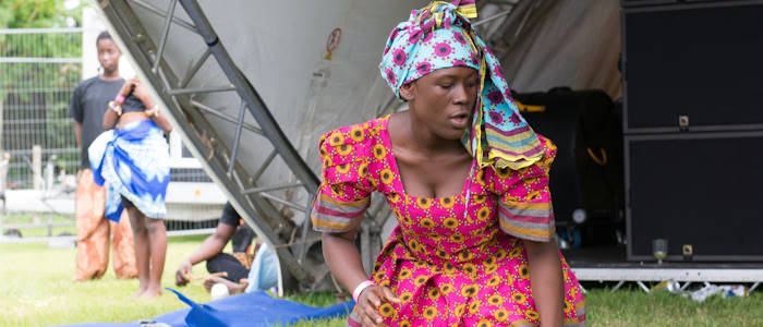 Noyam performer kneeling on ground at Solas Festival