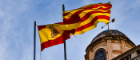 Spanish and Catalan flags flying next to each other in front of a building