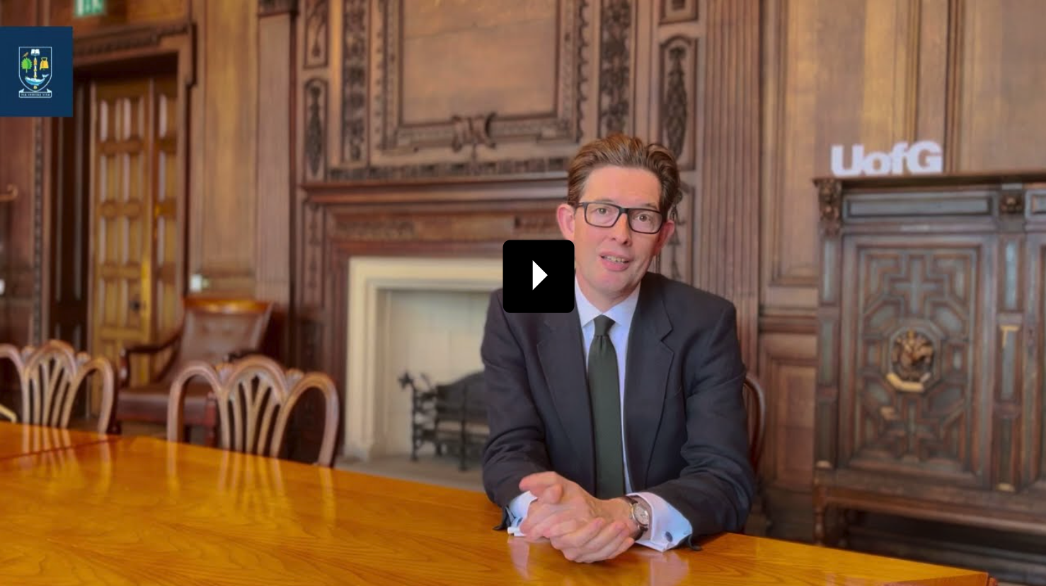 Ken McCallum, University of Glasgow Alumnus, sitting at table in classic style room.