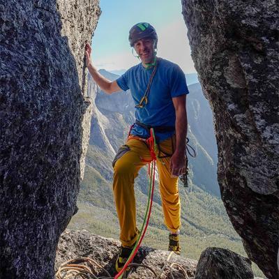 Full body photo of Dave Mcleod posing in between large rocks