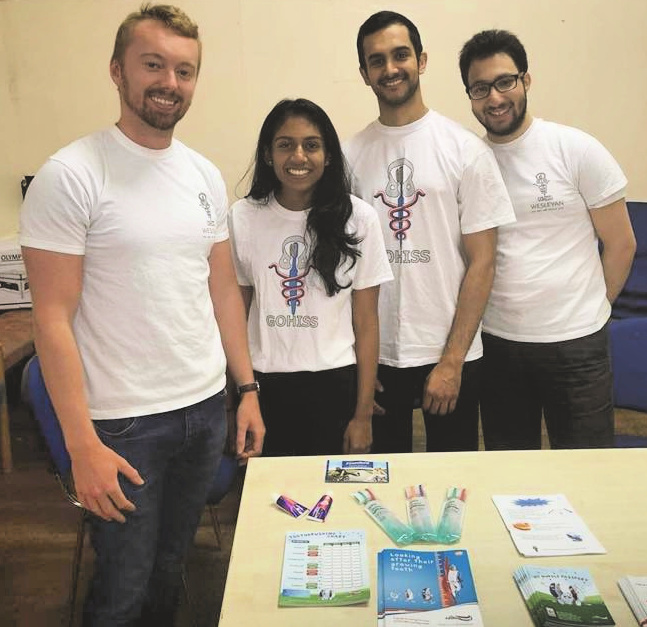 Photograph of four dental students with their stall at a foodbank