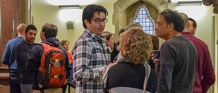 A picture of a group of people talking at a seminar