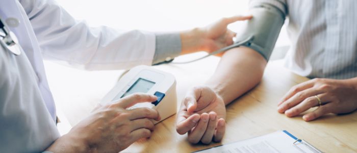 Close up of the hands of a doctor checking a patient's blood pressure