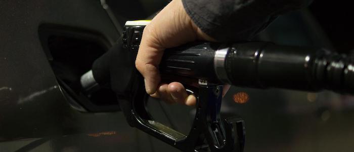 A person's hand holding a petrol pump handle to put fuel into a dark gray car. Source: Rudy and Peter Skitterians, Pixabay https://pixabay.com/users/skitterphoto-324082/