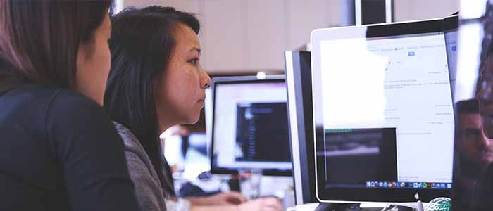 A woman looking at a computer screen as she works